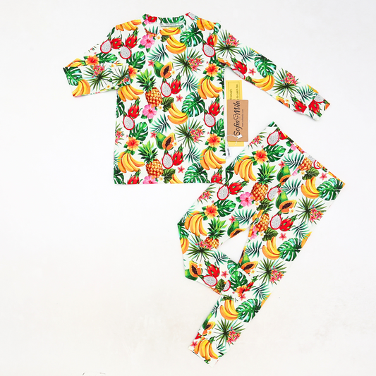 Tropical fruit patterned baby outfit with matching hat on a white background