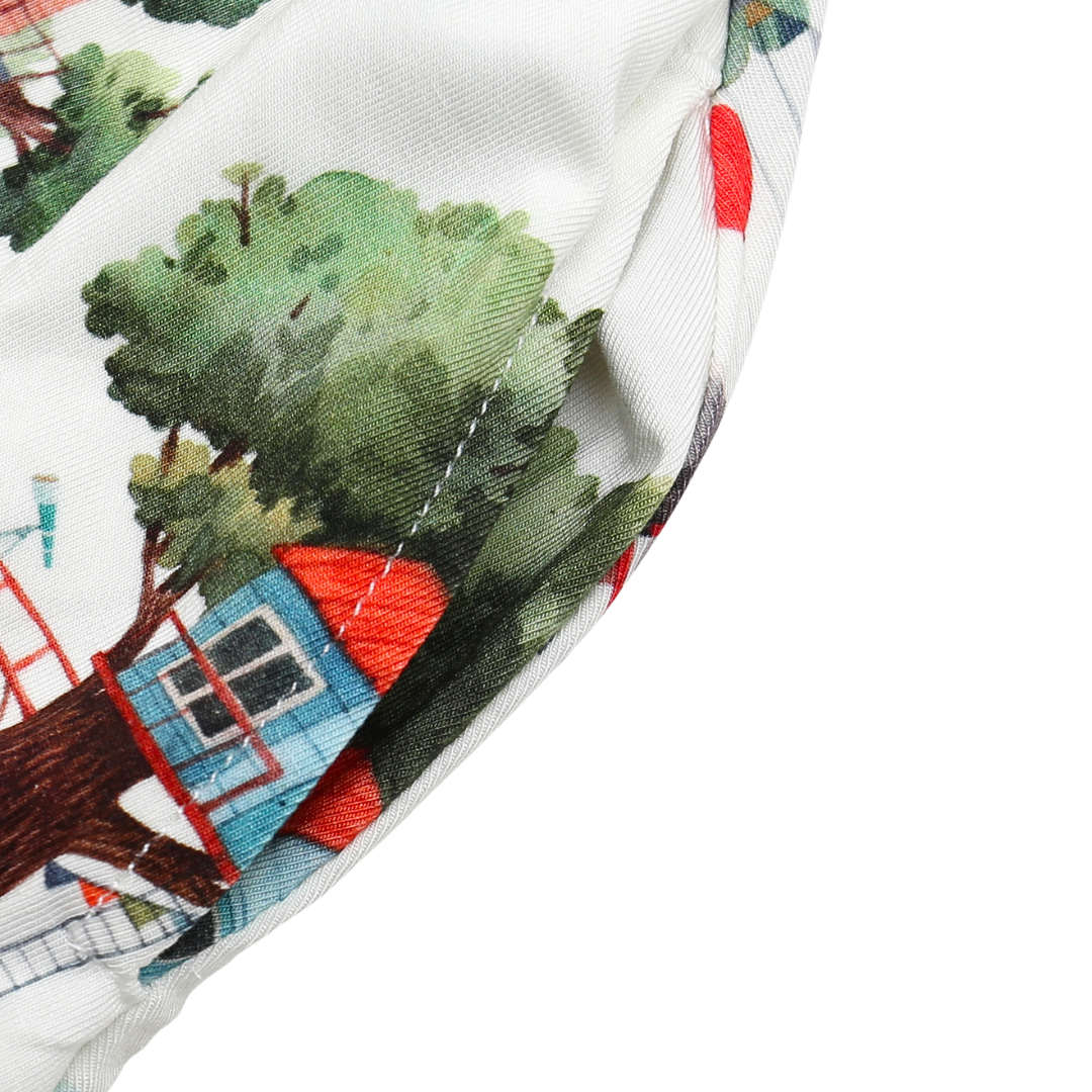 Close-up of fabric with embroidered tree house design on a white background