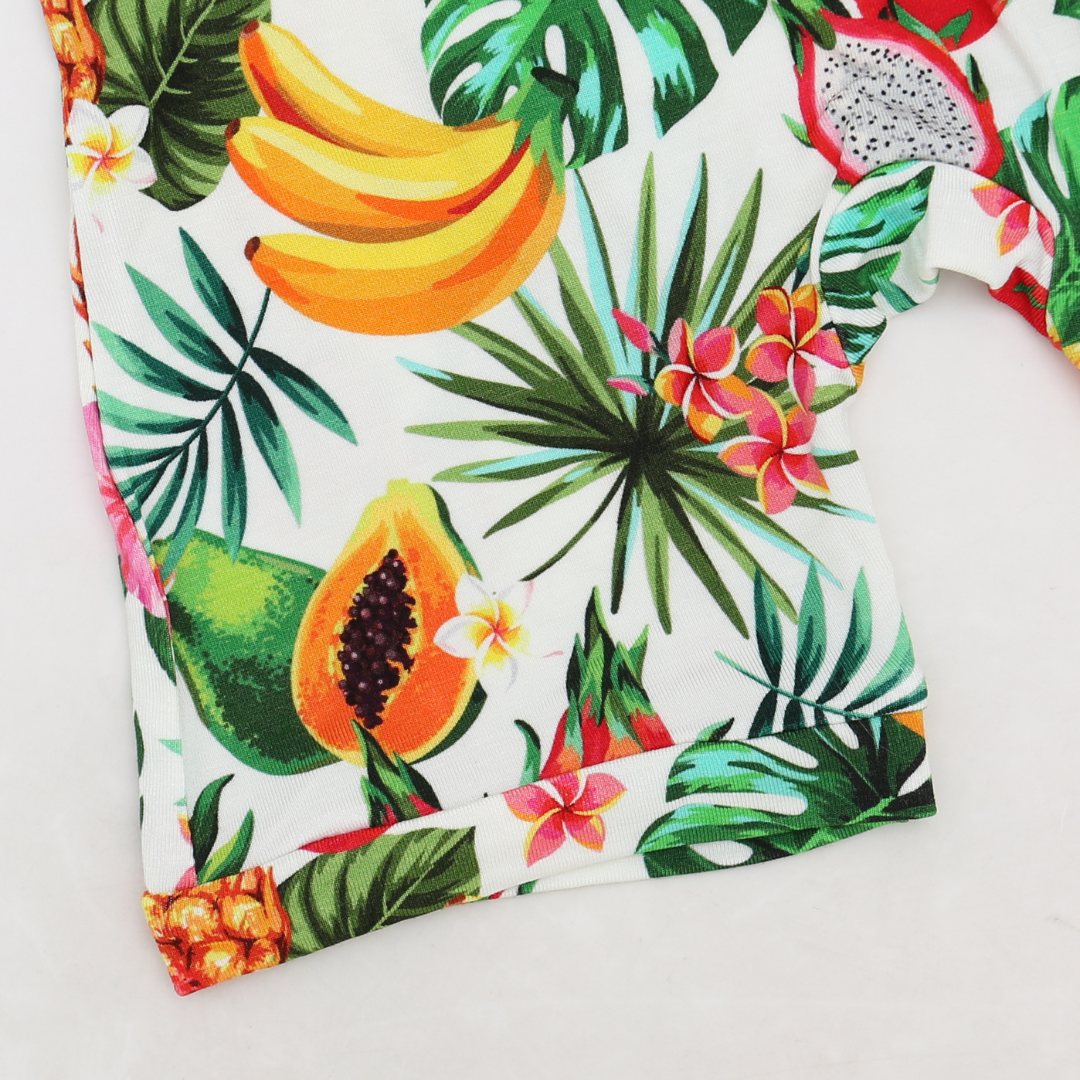 Tropical fruit and leaf patterned fabric on a white background