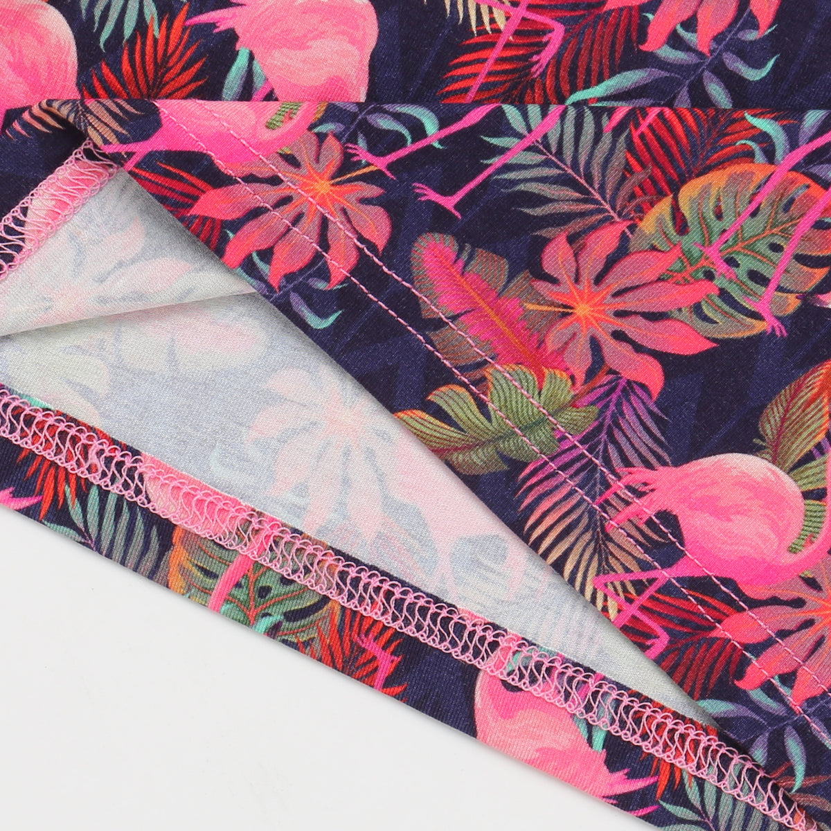 Fabric with pink flamingo and leaf pattern on a white background