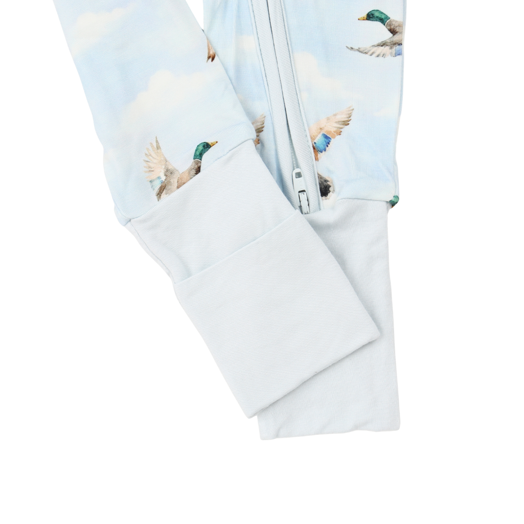 Folded baby swaddle with duck pattern on a light blue background