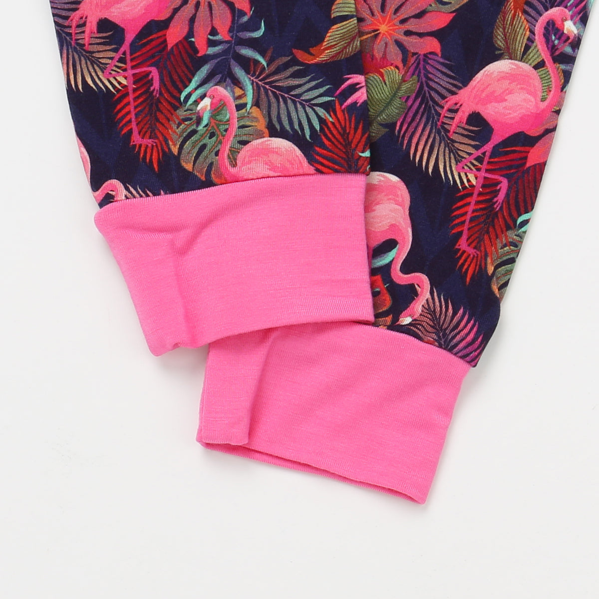 Pink flamingo and leaf patterned fabric on a white background